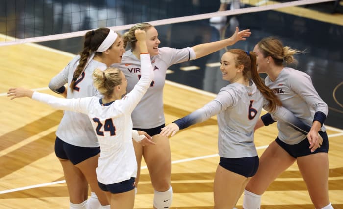 The Virginia volleyball team celebrates after scoring a point.